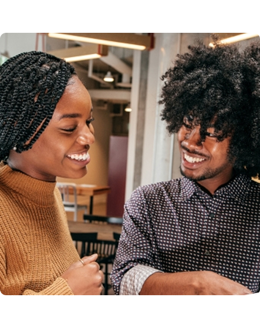 Two adults working on separate laptops