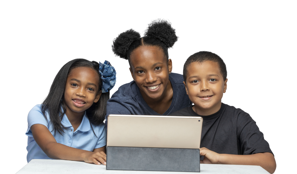 Children making use of separate computers in a classroom with one of them looking at the camera with a smile